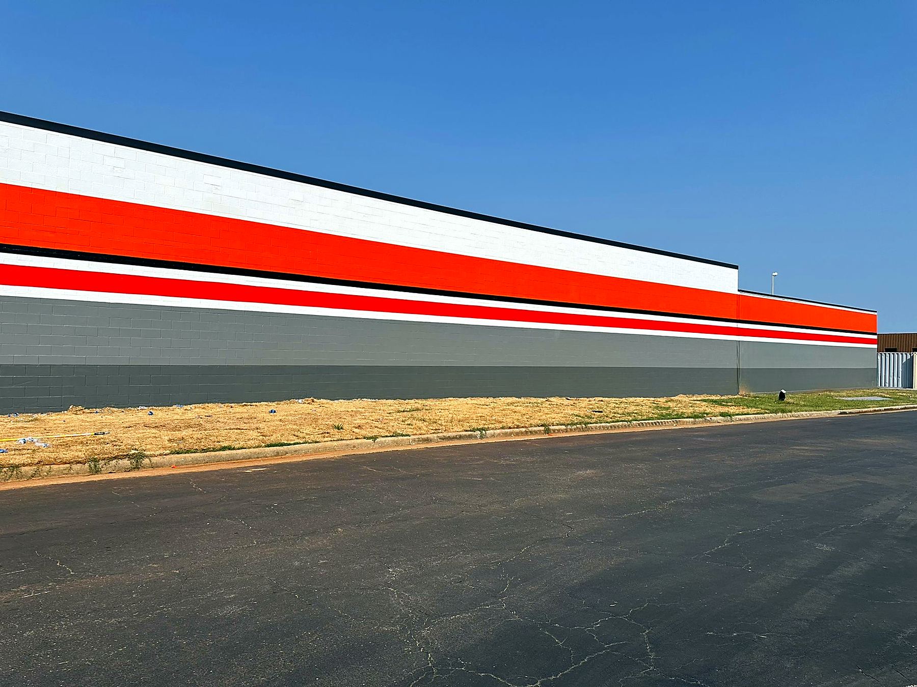 AutoZone exterior with painted CMU and brand stripes